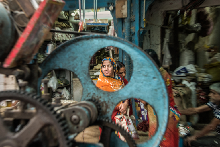 Mujer a través de máquina de jugo de caña, Bikaner, India 2015