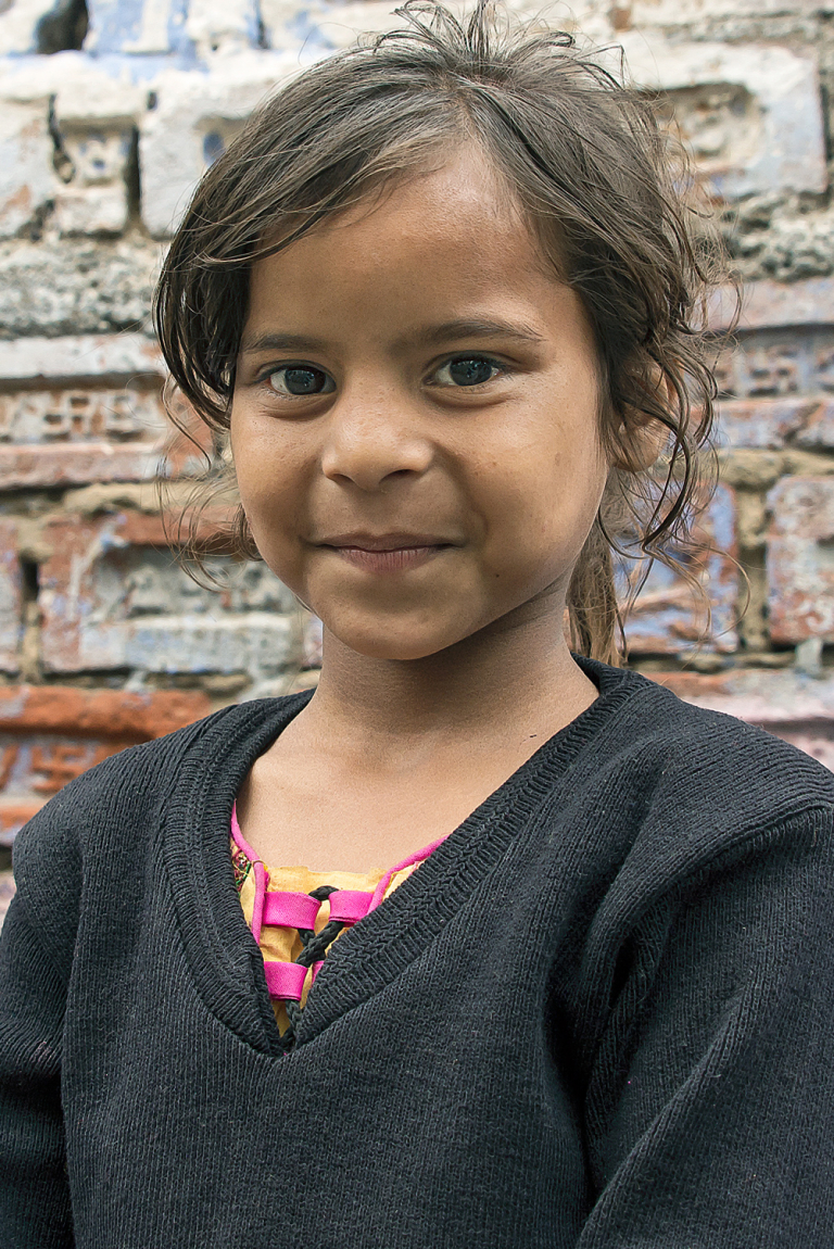 Retrato de niña sonriente, bloques de construcción, Fathepur, India 2015