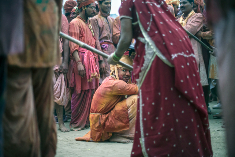 retrato de joven con sonrisa, Mujeres golpean a hombres con palos de bambu, Festival Holi, Barsana, India 2015