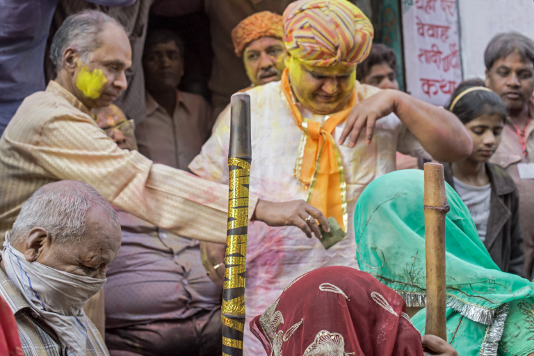 Mujeres golpean a hombres con palos de bambu, dinero, Festival Holi, Barsana, India 2015